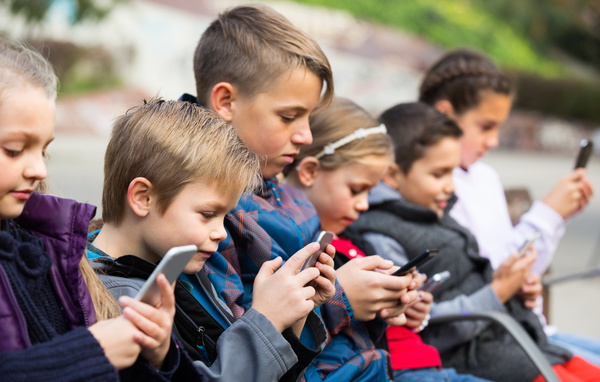 Group of children using mobile devices.