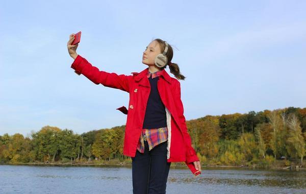 Teenage girl taking a selfie with her phone.