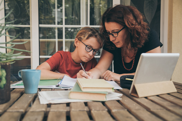 Parent helping a child with school work.