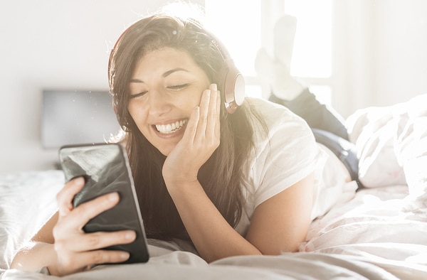 Teen lying down looking at her phone.