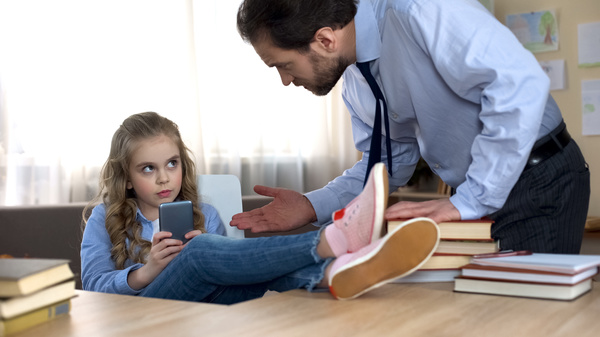 Parent talking to their child using a phone.