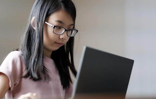 Young girl looking at a laptop.