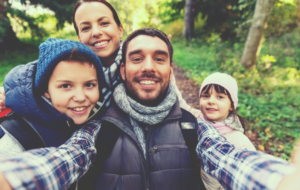 Family posting outside together for a selfie.
