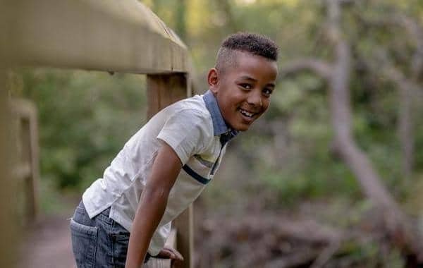 Young boy leaning over a railing.
