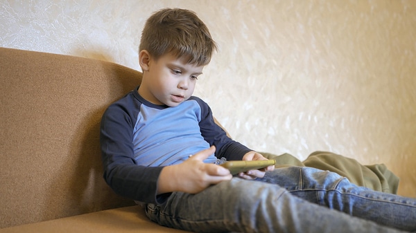 Young boy looking at his phone screen.