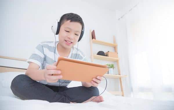 Young teen boy looking at a tablet.