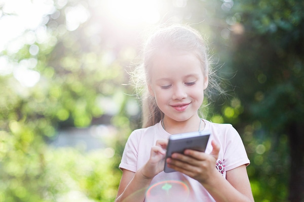 Young girl typing on a phone.
