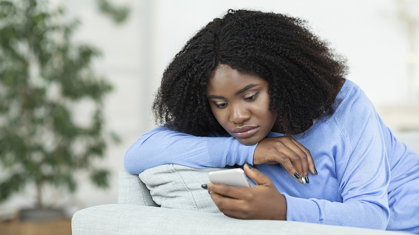 Sad teen looking at her phone.