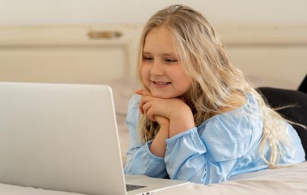 Young teen looking at a laptop screen.