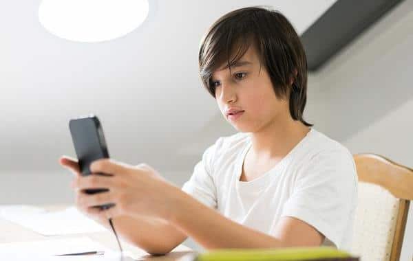 Teenage boy looking at his phone.