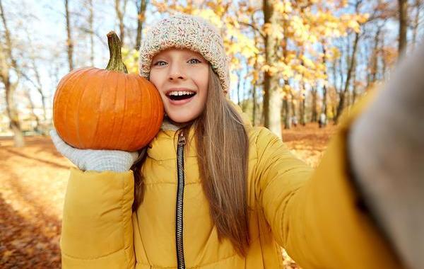 Girl holding a pumpkin.